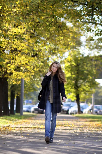 Beautiful young woman walking in autumn park — Stock Photo, Image