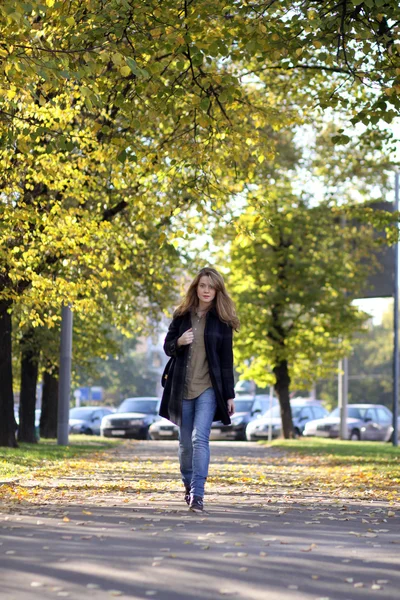 Vacker ung kvinna promenader i höstparken — Stockfoto