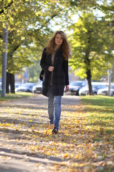 Vacker ung kvinna promenader i höstparken — Stockfoto