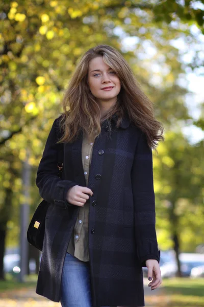 Beautiful young woman walking in autumn park — Stock Photo, Image