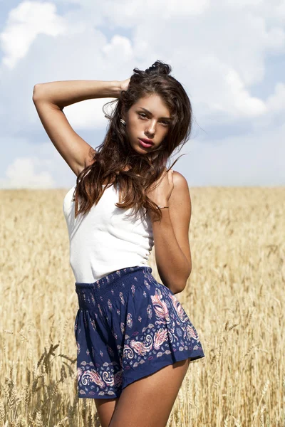 Mladá žena v pšeničném zlatém poli — Stock fotografie