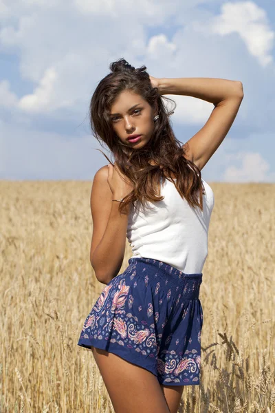 Junge Frau in einem goldenen Weizenfeld — Stockfoto
