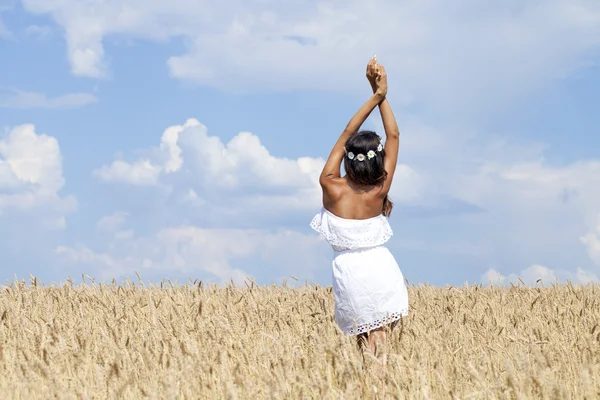 Ung kvinna på ett vetefält — Stockfoto