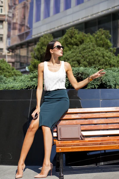 Gyönyörű üzleti nő ül egy padon — Stock Fotó