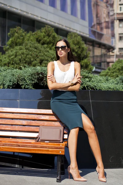 Mulher de negócios bonita sentada em um banco — Fotografia de Stock