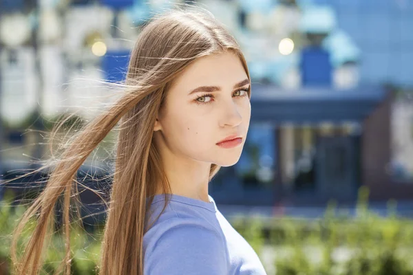 Bir yaz parkının arka planında genç bir kızın yakın plan portresi