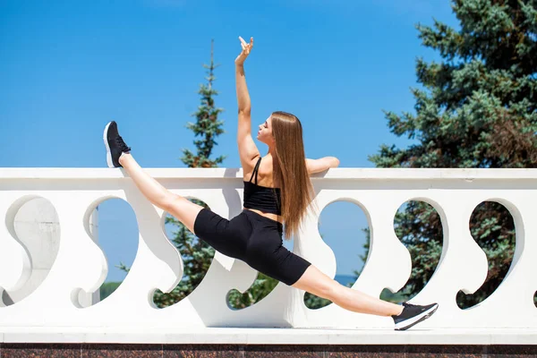 Spor üniformalı genç kız dışarıda spor yapıyor.