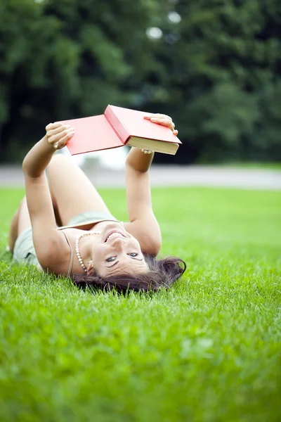 Jovem menina bonita lendo um livro ao ar livre — Fotografia de Stock