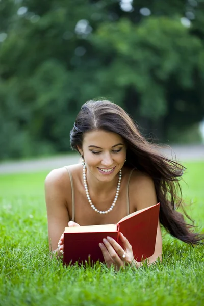 Jeune belle fille lisant un livre en plein air — Photo
