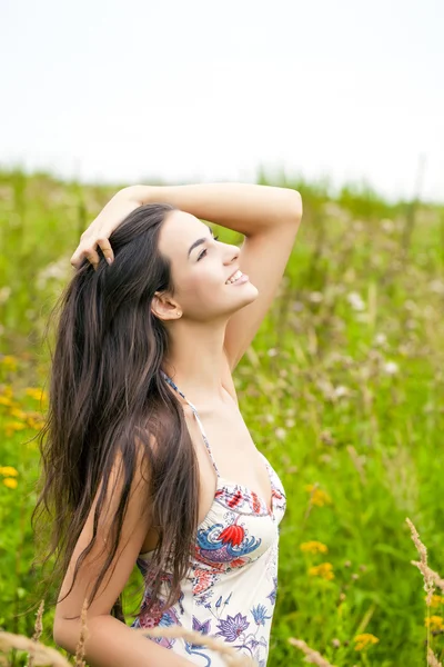 Schöne junge Frau in buntem Kleid — Stockfoto