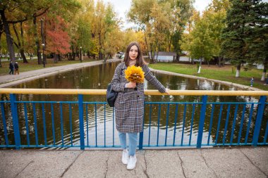 Gri paltolu güzel esmer bir kızın vücut portresi. 