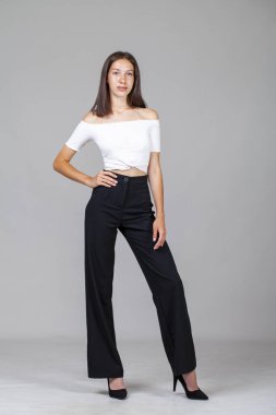 Stüdyoda gri arka planda izole edilmiş güzel bir kızın portresi.