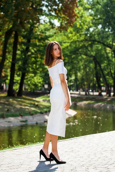 全长的肖像画 一个穿着白裙子的年轻漂亮的女孩在夏日的公园里摆姿势 — 图库照片
