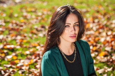 Sonbahar parkında orta yaşlı doğulu bir kadının portresi