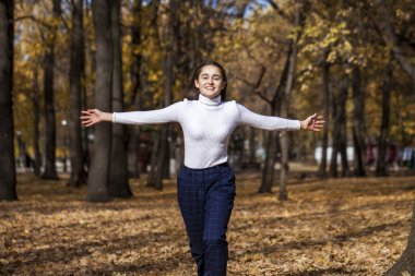 Güz parkında genç ve güzel bir esmer kadının portresi.