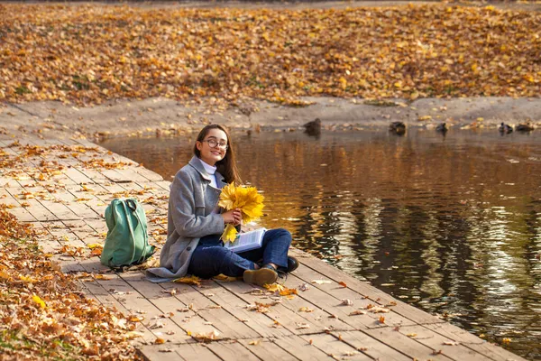 Молодая Красивая Школьница Сидит Осеннем Парке Учебником — стоковое фото