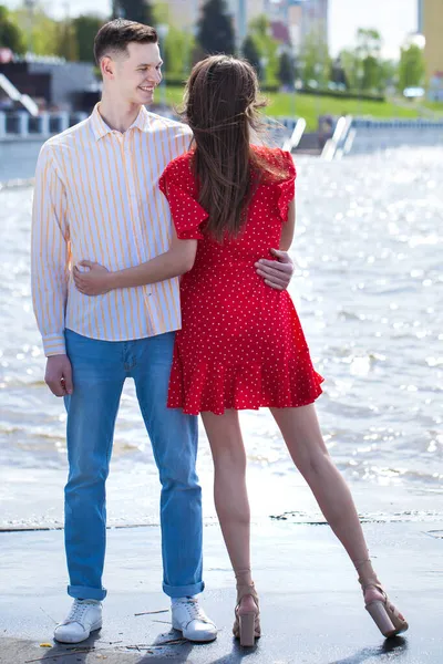 Giovane Ragazzo Abbraccia Sua Ragazza Vestito Rosso — Foto Stock