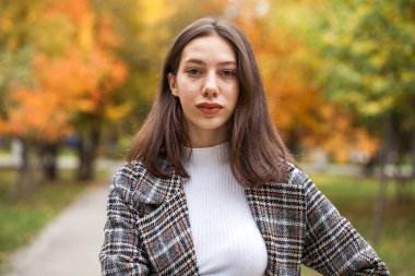 Yüzünde çiller olan güzel kahverengi saçlı bir kızın portresi.