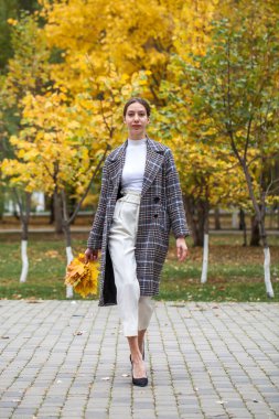 Gri paltolu güzel esmer bir kızın vücut portresi. 