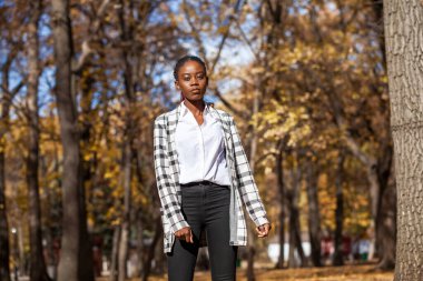 Güz parkında poz veren güzel esmer kadının portresi. 