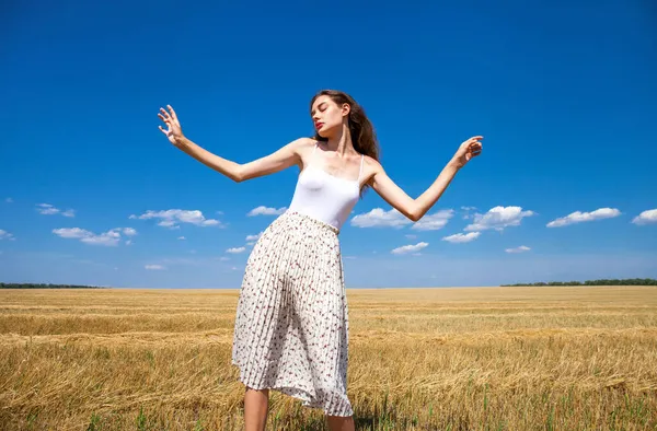 若いです美しい女の子の背景にある麦畑と青空 — ストック写真