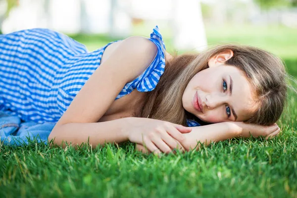 年轻美丽的金发姑娘躺在草坪上 夏日公园在室外 — 图库照片
