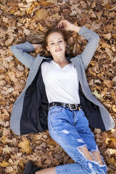 나뭇잎 배경에 아름다운 소녀의 — 스톡 사진