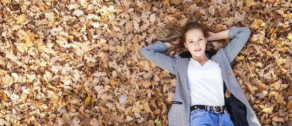 Üst Manzara Sonbahar Sarı Yapraklarının Arka Planında Güzel Bir Genç — Stok fotoğraf