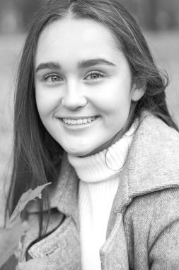 Güz parkında genç ve güzel bir esmer kadının portresi.