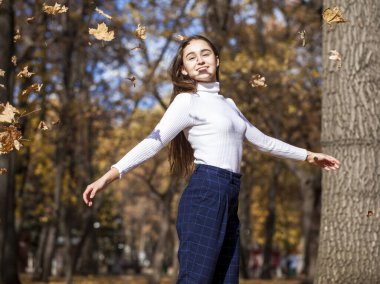 Güz parkında genç ve güzel bir esmer kadının portresi.