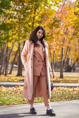 Güz parkında genç ve güzel bir esmer kadının portresi.