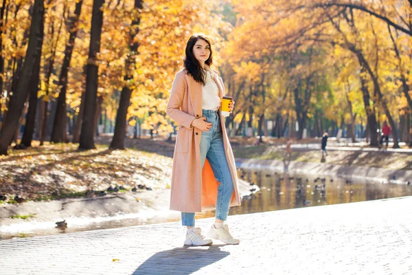 秋の公園を背景にポーズをとる少女の全長の肖像画 — ストック写真