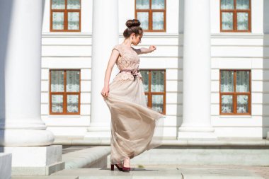 Sokakta poz veren bej elbiseli güzel bir esmer.