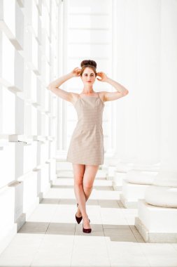 Sokakta poz veren bej elbiseli güzel bir esmer.