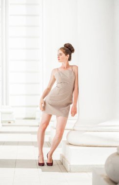 Sokakta poz veren bej elbiseli güzel bir esmer.