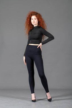 Gri bir arka planda izole edilmiş güzel kızıl saçlı bir kızın portresi.