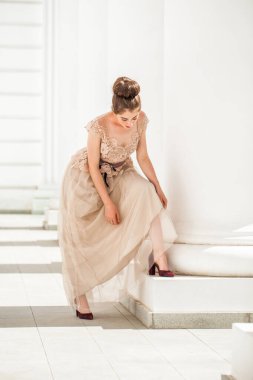 Sokakta poz veren bej elbiseli güzel bir esmer.