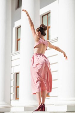 Sokakta poz veren pembe elbiseli güzel bir esmer.