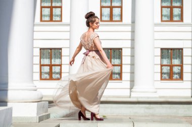 Sokakta poz veren bej elbiseli güzel bir esmer.