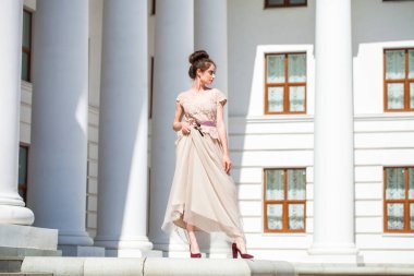 Sokakta poz veren bej elbiseli güzel bir esmer.