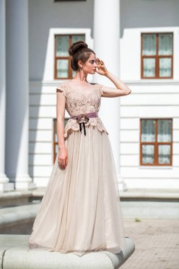 Sokakta poz veren bej elbiseli güzel bir esmer.