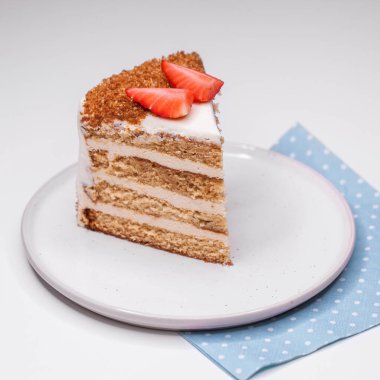 Çilek dilimleriyle süslenmiş ev yapımı ballı pasta.