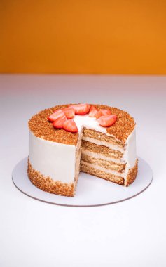 Çilek dilimleriyle süslenmiş ev yapımı ballı pasta.