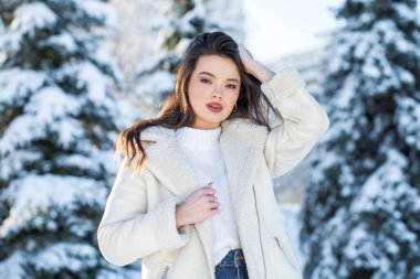 Kış parkında genç ve güzel bir esmer kadının portresi.