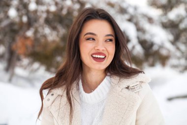 Kış parkında genç ve güzel bir esmer kadının portresi.