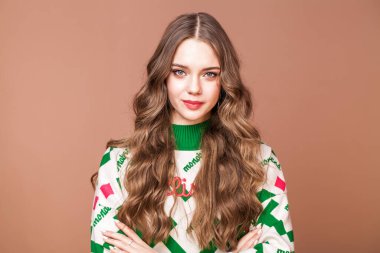 Bej arka planda genç ve güzel bir kızın stüdyo portresi.