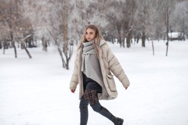 Beyaz kazaklı güzel sarışın bir kızın yakın portresi.