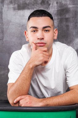 Beyaz tişörtlü bir gencin portresi.