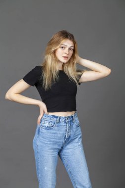 Gri arka planda izole edilmiş güzel sarışın bir mankenin yakın portresi.