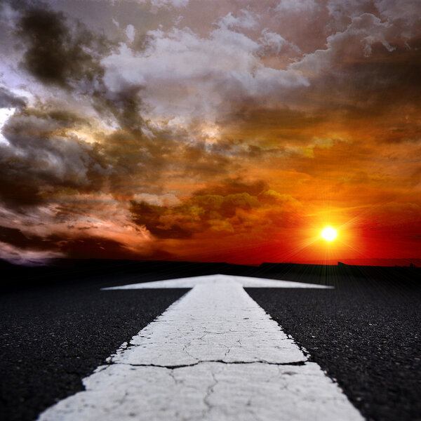 Асфальтовая дорога в сумерках со стрелкой
